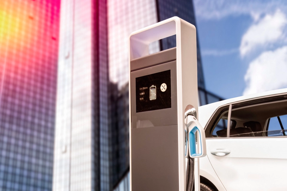 E-Auto an einer Ladestation vor einem Wolkenkratzer