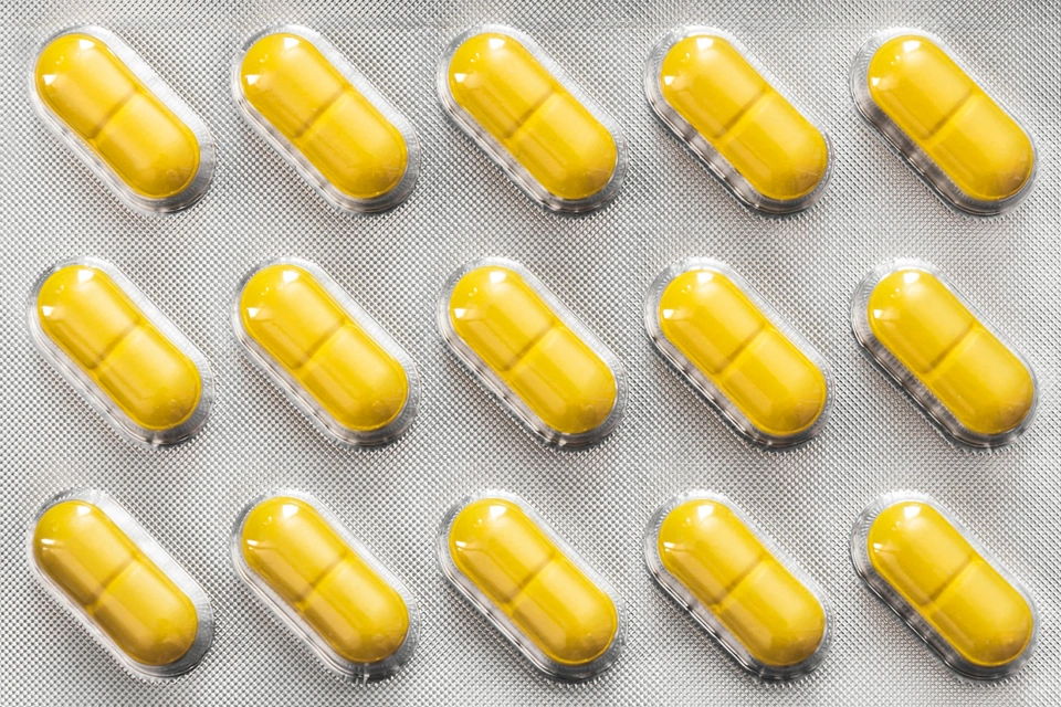 Shiny yellow pills pack close up how the background
